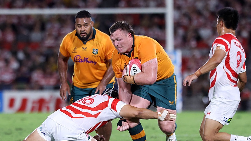 Angus Bell of Australia is tackled by Mamoru Harada of Japan during the Lipovitan D Challenge Cup between Japan and Australia. 