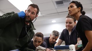 Robby and Samira looking at a monitor off-camera as they fight to save someone's life in The Pitt season 2