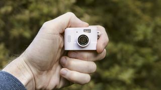 Miniature pink keychain camera, the 'Photo Creator Mini Digital Camera series 3', in user's hand