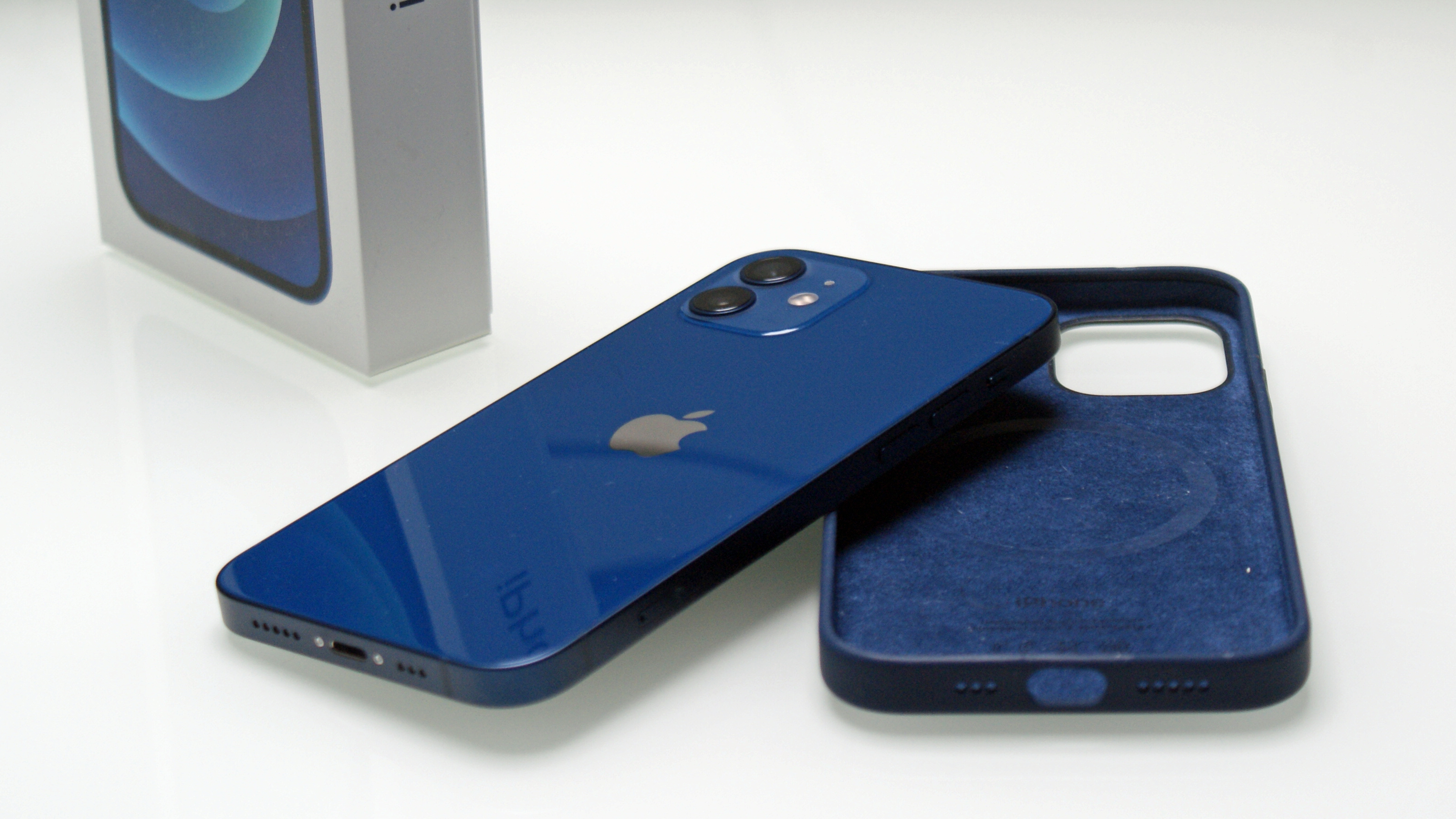 An iPhone 12 next to a case for the phone