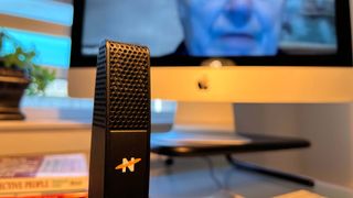 A Neat Skyline microphone on a desk during a conference call