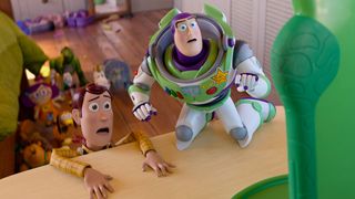 Woody looking shocked as he pulls himself up onto a table while a worried-looking Buzz kneels next to him in Toy Story 5