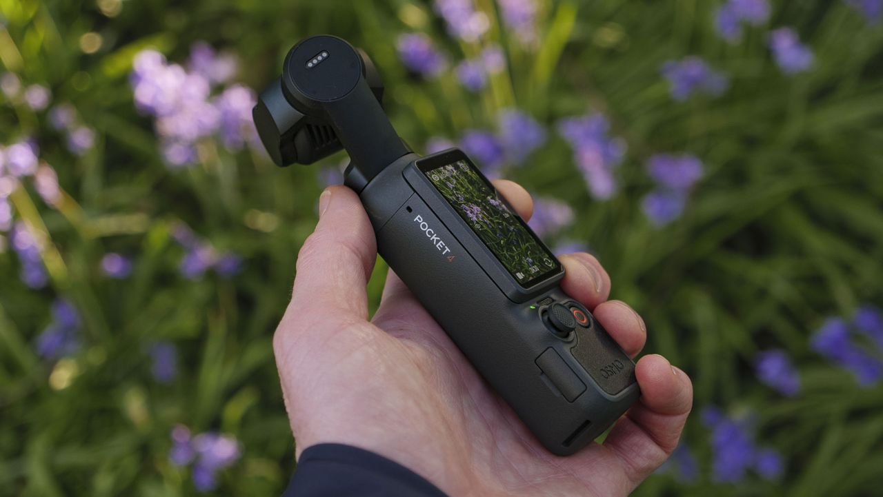 Side profile of the DJI Osmo Pocket 4 vlogging camera with natural background of bluebells