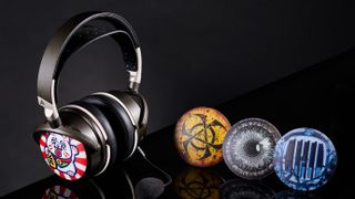 An Audeze Maxwell 2 gaming headset on a black surface accompanied by four of the new ReSkin earcup designs.