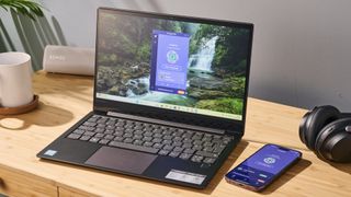 PrivadoVPN Free apps running on an open laptop and a mobile, lying on a desk.