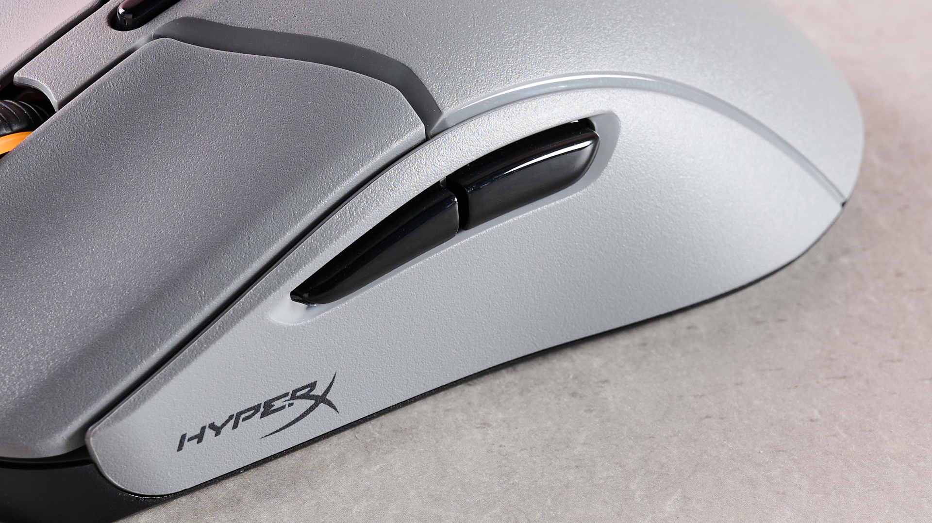 Close-up of side buttons on HyperX Pulsefire Haste 2 Pro on desk