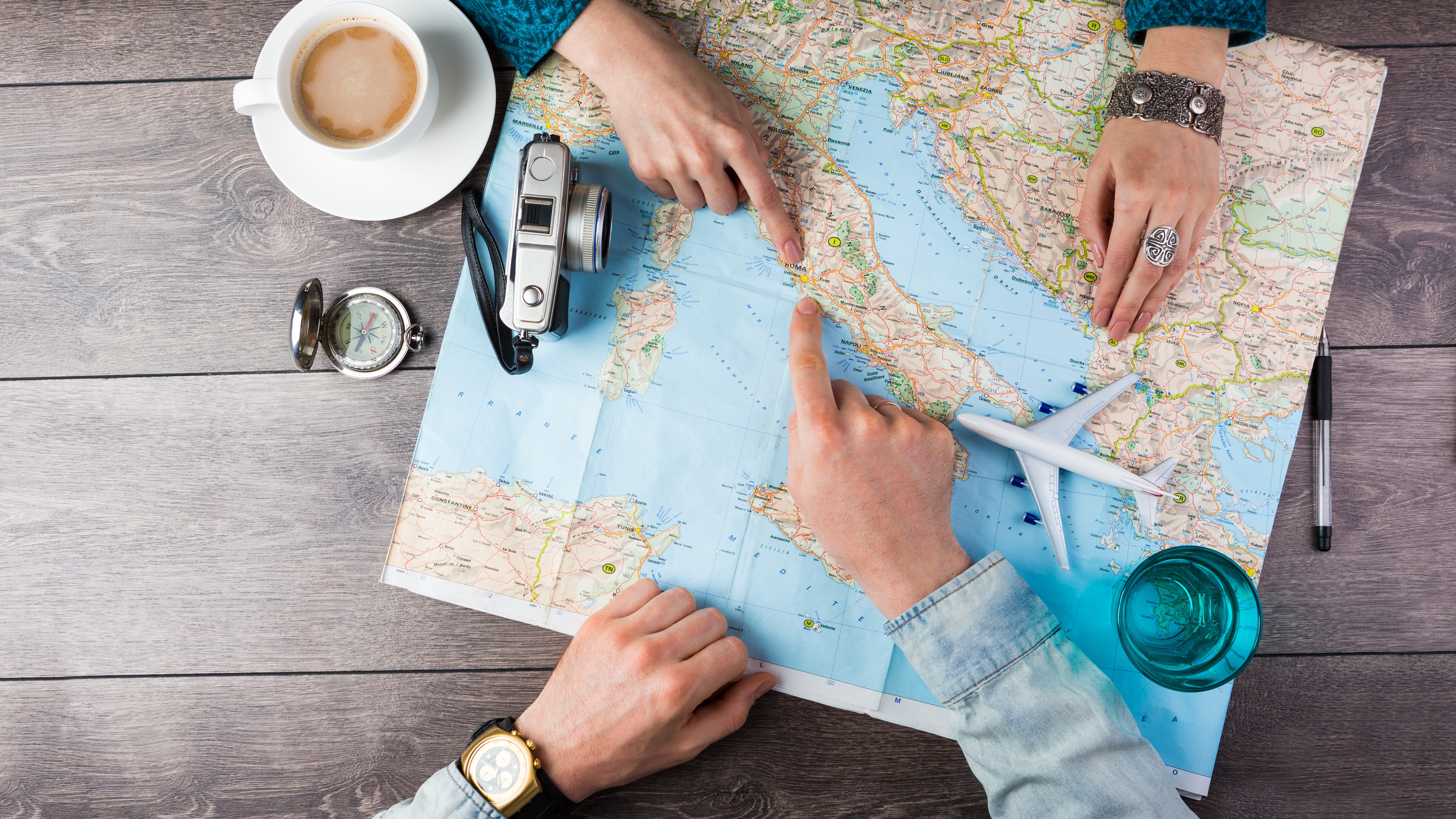 Young couple planning honeymoon vacation trip with map