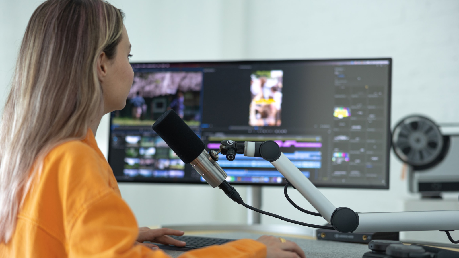 Content creator in front of monitor and microphones