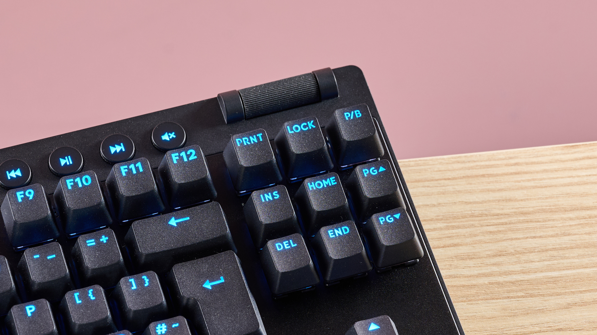Close-up of volume wheel on Logitech Pro X TKL Rapid, on table with pink background