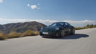 A 2025 Porsche 911 in motion beneath a blue and almost cloudless sky