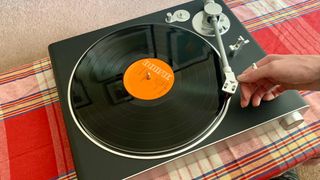 Victrola Stream Carbon turntable playing David Bowie, with the tonearm being operated