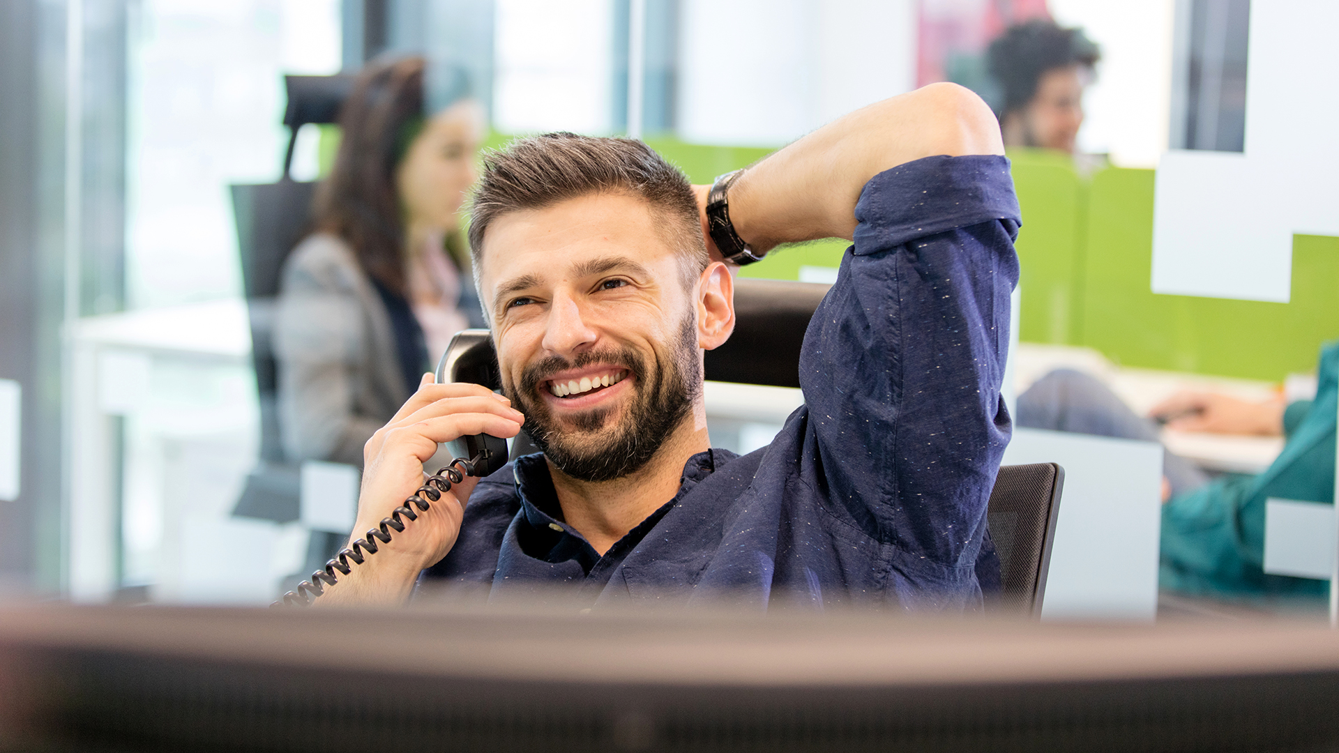 A man in an office on a phone call.