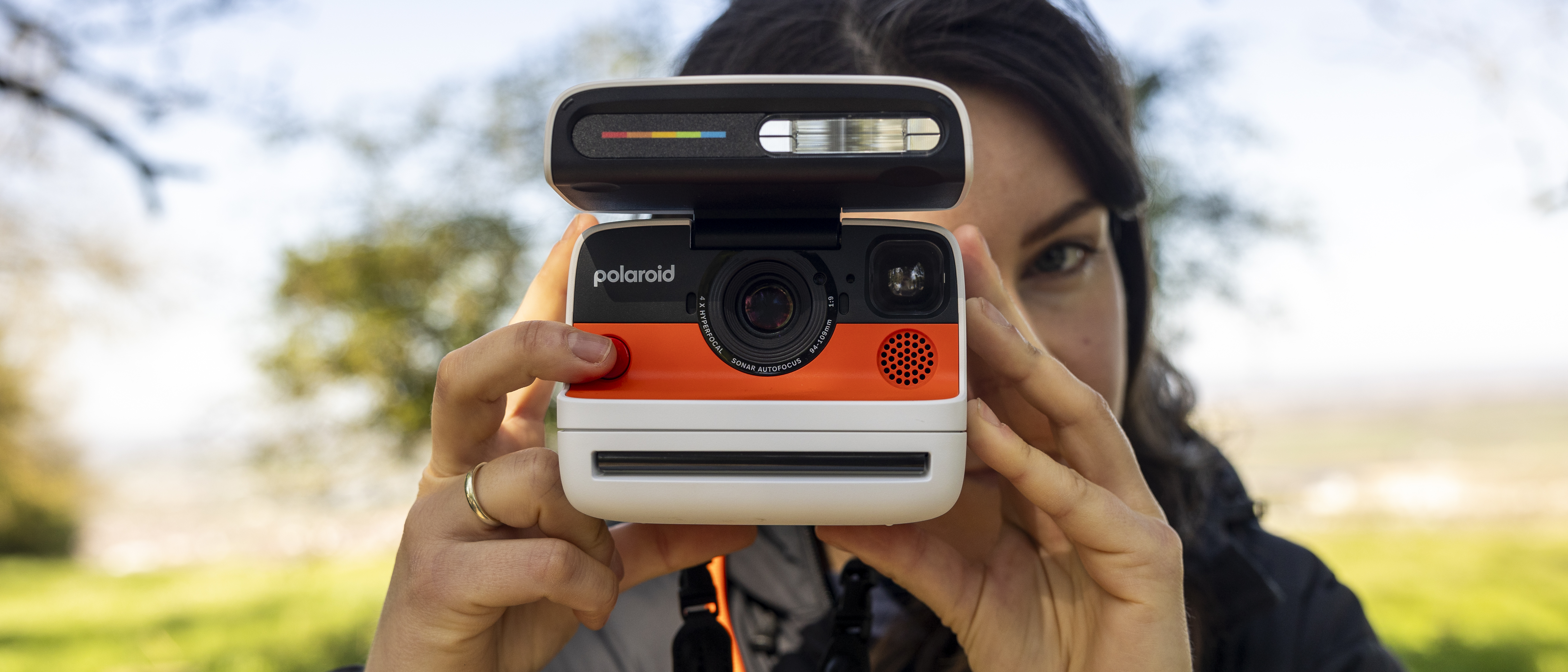 A female photographer holds the Polaroid Flip instant camera up to her face
