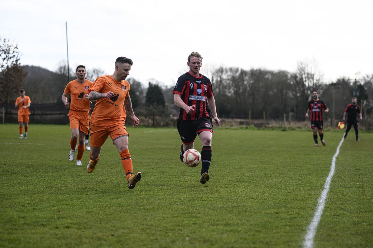 Some footballers playing in a field