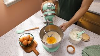 Person making cake using KitchenAid Artisan stand mixer in Mint