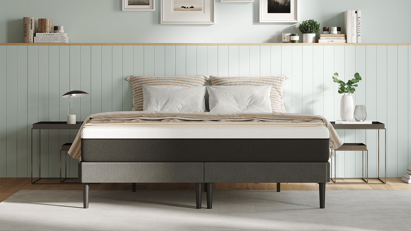 The Emma Mattress shown on a grey wooden bed frame