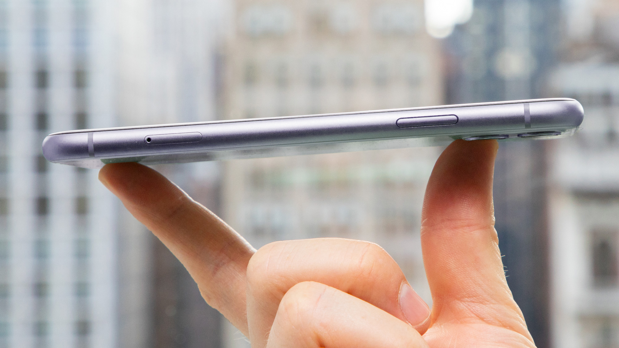 An iPhone 11 in someone's hand, from the side