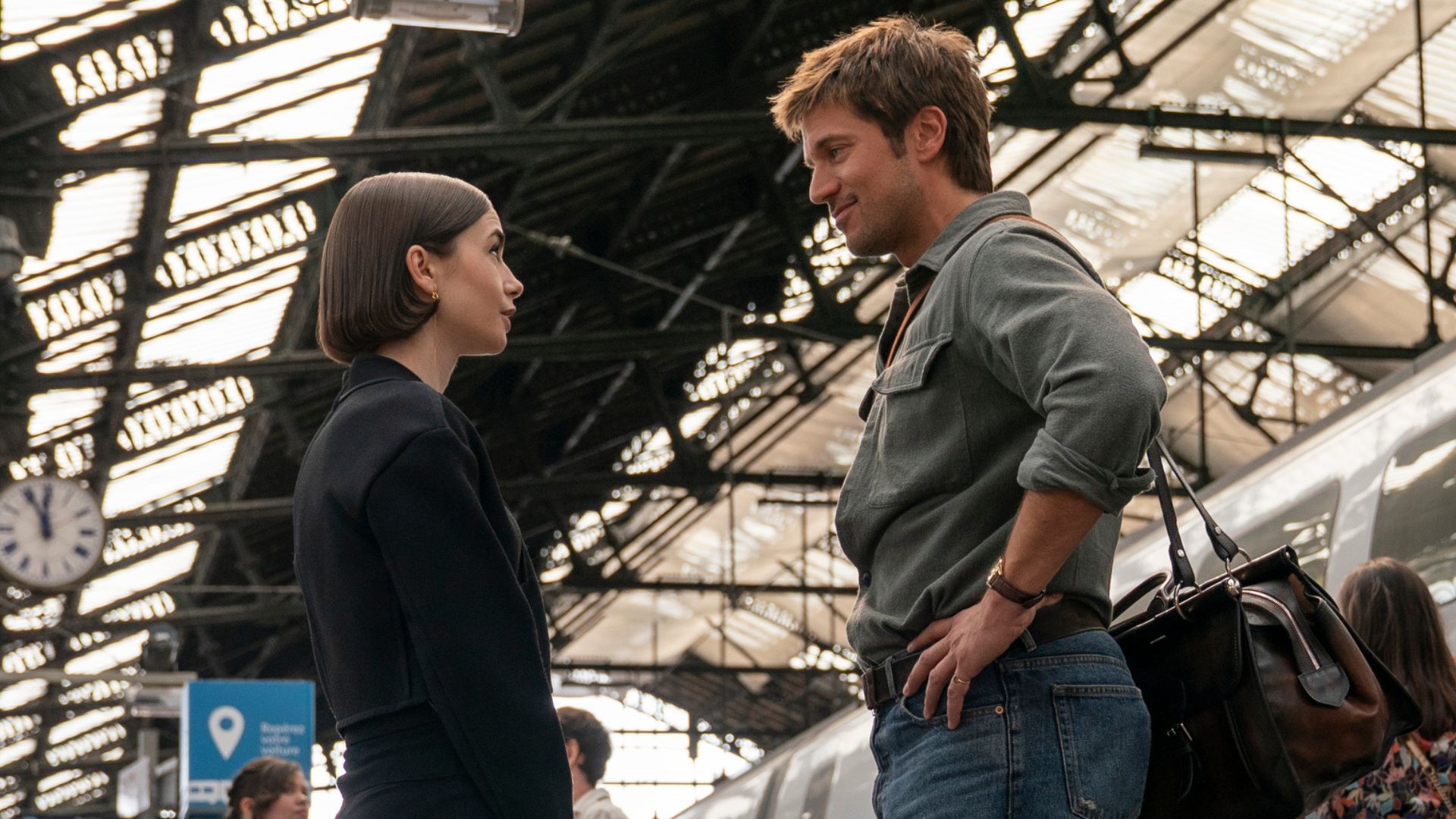 Emily and Gabriel talk on a train platform