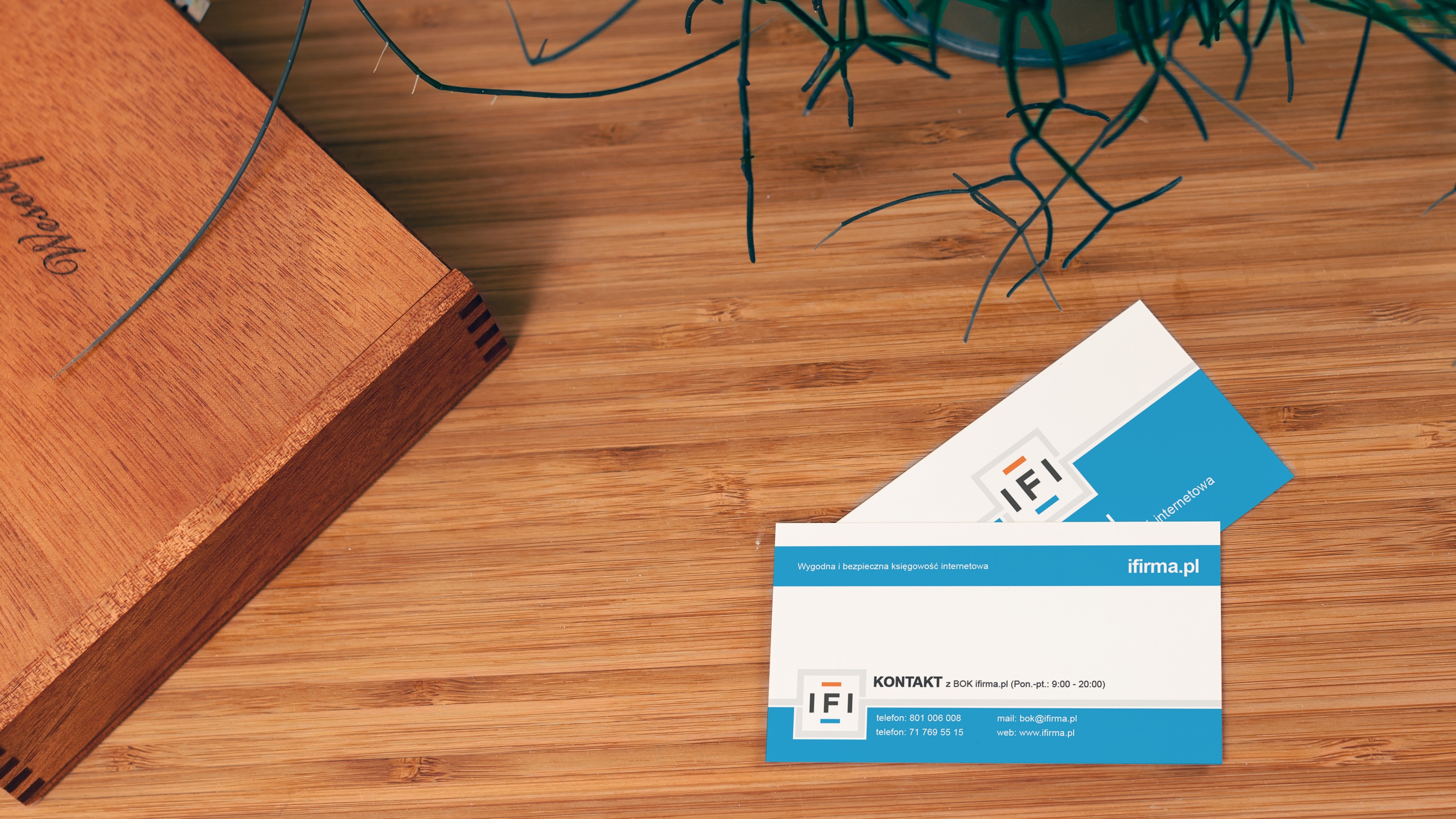 A pair of business cards on a desk.