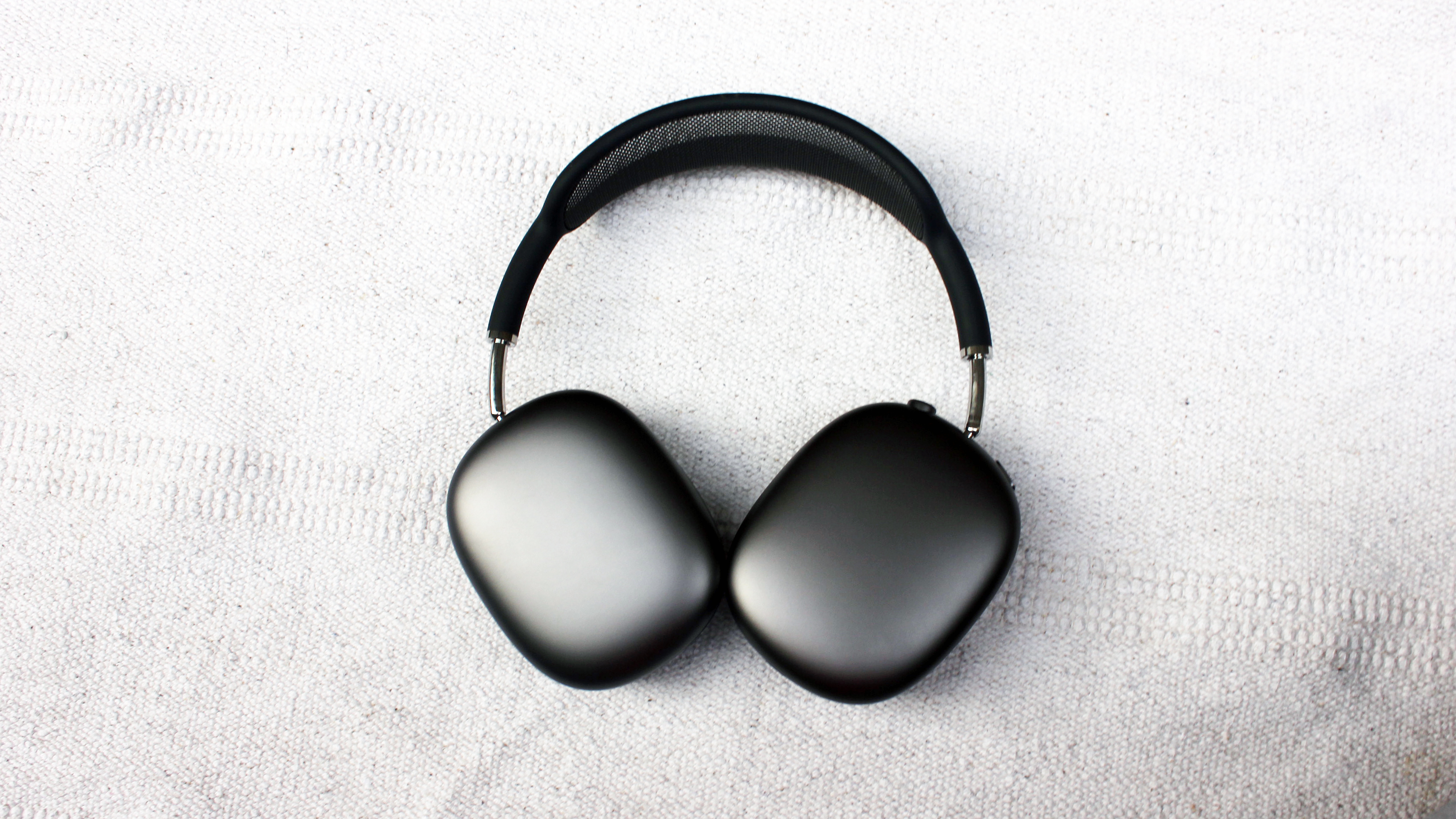 The Apple AirPods Max over-ear headphones pictured on a light grey surface