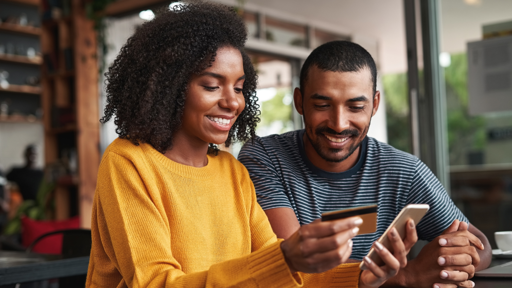 Person buying something on their smartphone, holding a credit card