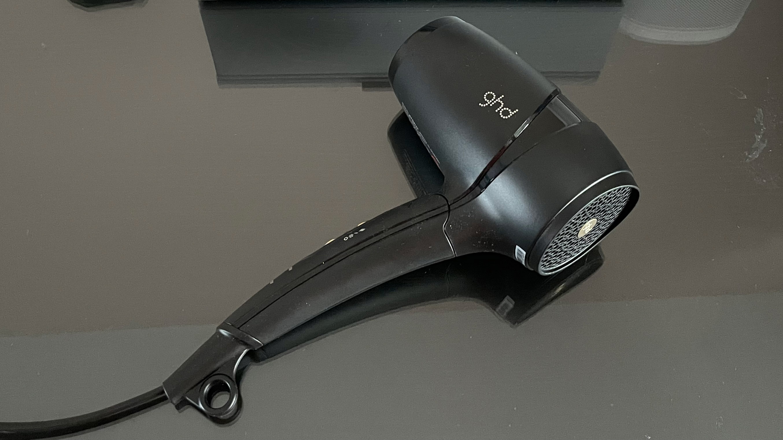 The GHD Flight resting on the glass top of a dressing table