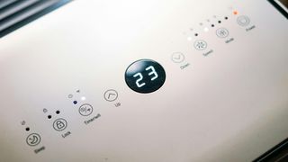 Close-up of a sleek air conditioner control panel displaying temperature