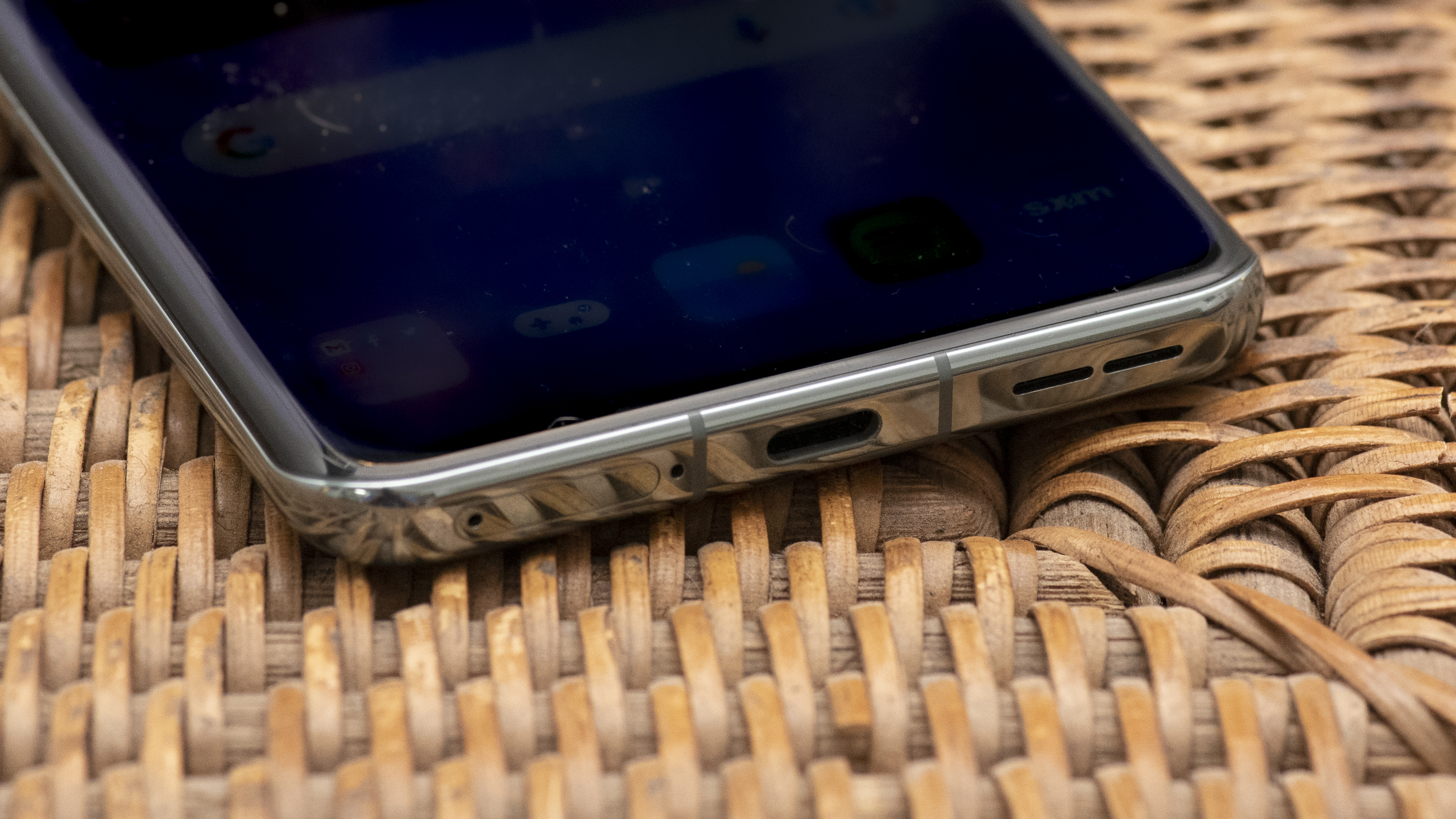 OnePlus 11 in green on wicker basket top with screen on