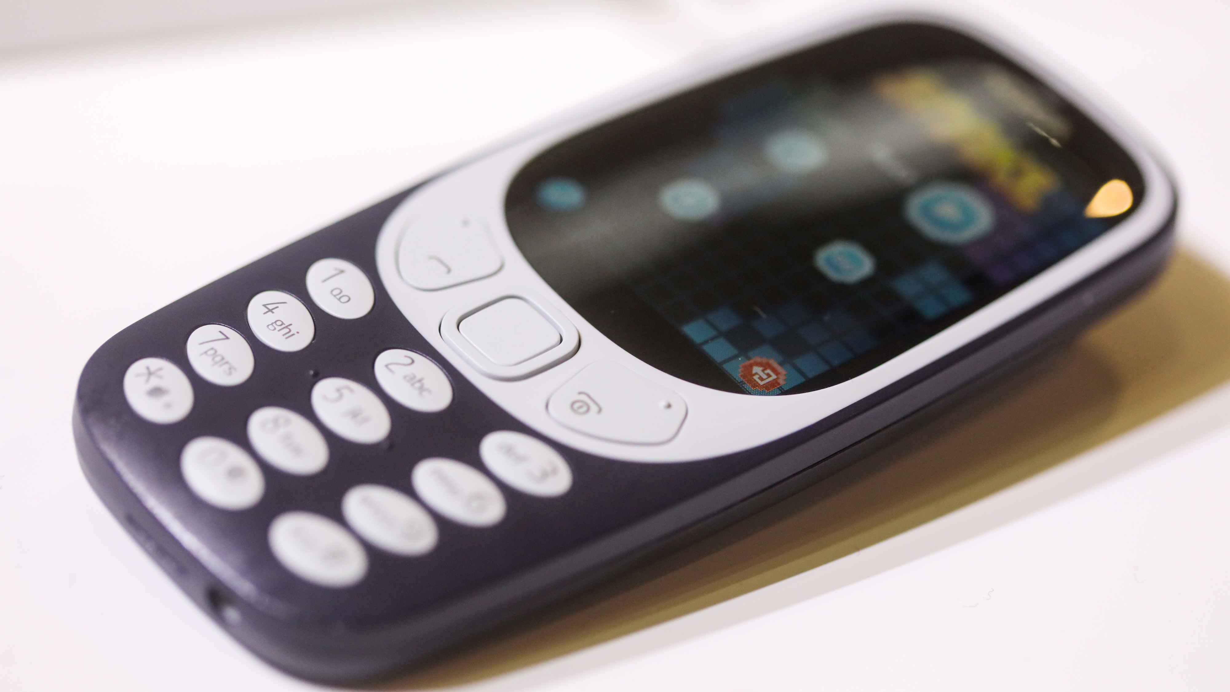 A Nokia 3310 phone on a white table