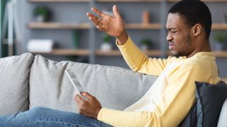 man looking angry at tablet
