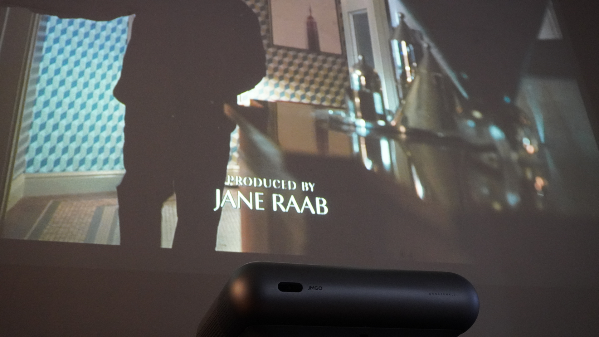 The JMGO O1 Pro Ultra Short Throw projector setup in a living room.