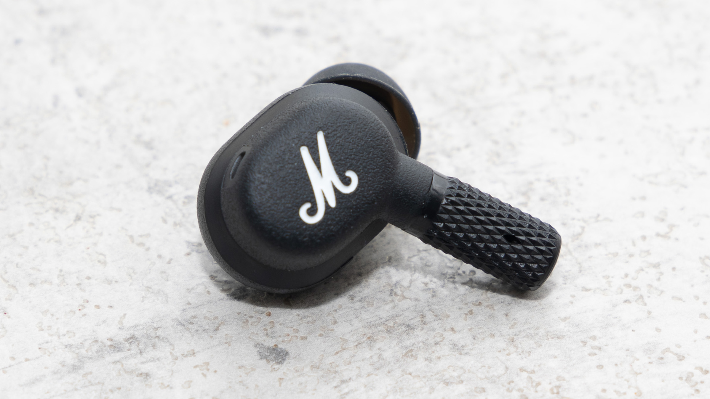 a closeup of one marshall motif anc earbud