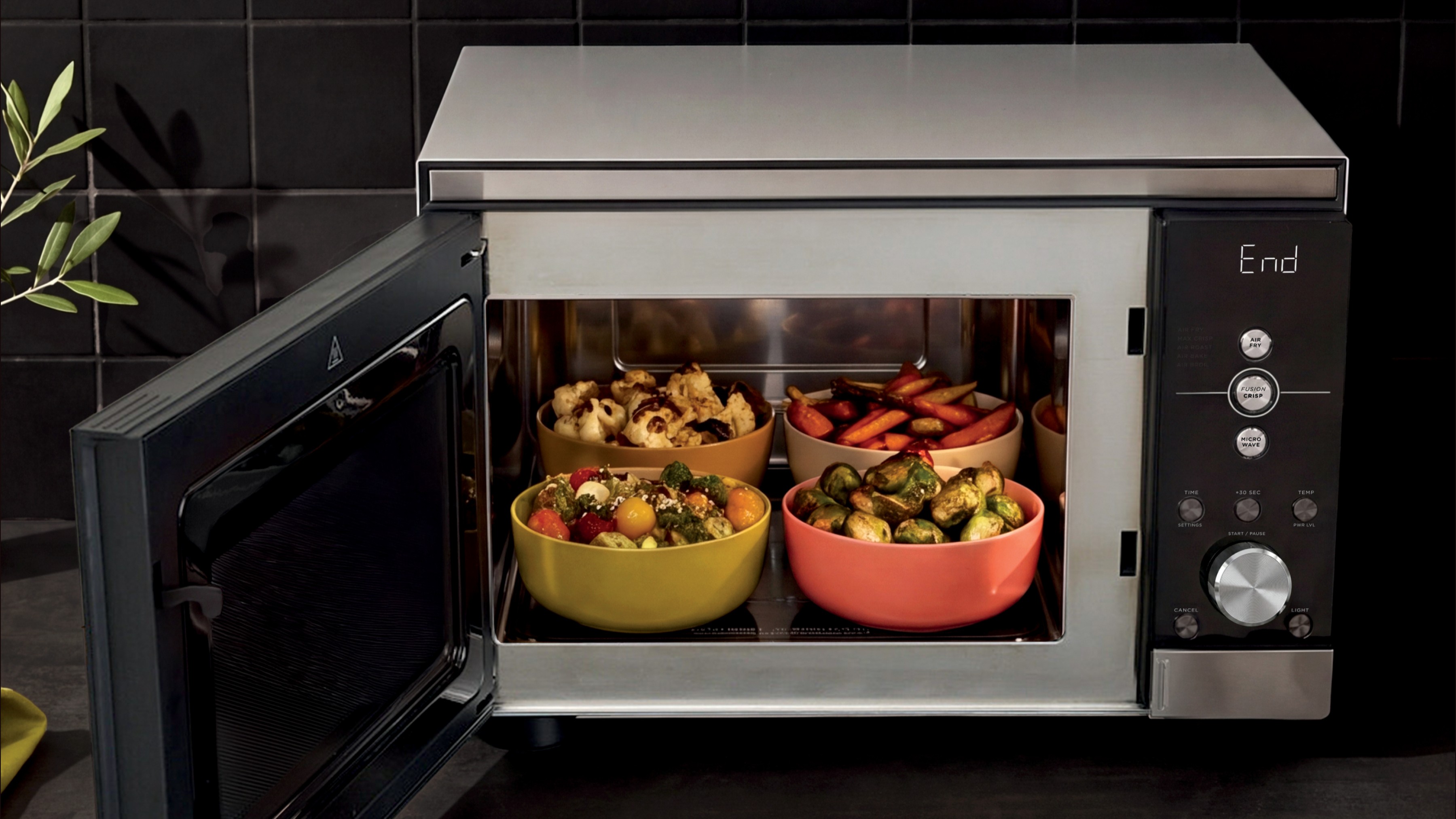 Ninja Crispi Microwave containing four dishes of various vegetables