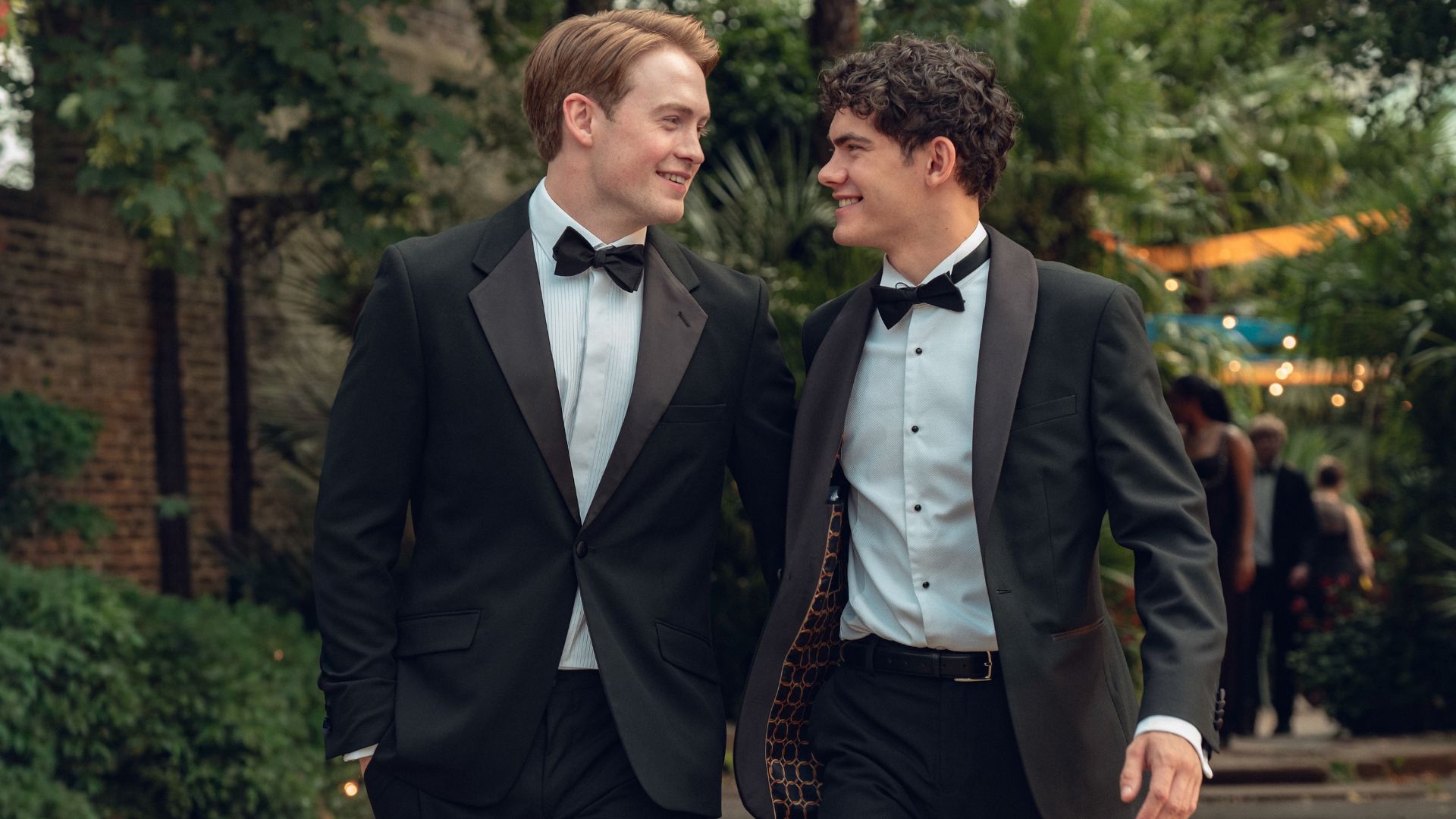 Nick and Charlie look at each other walking down the street