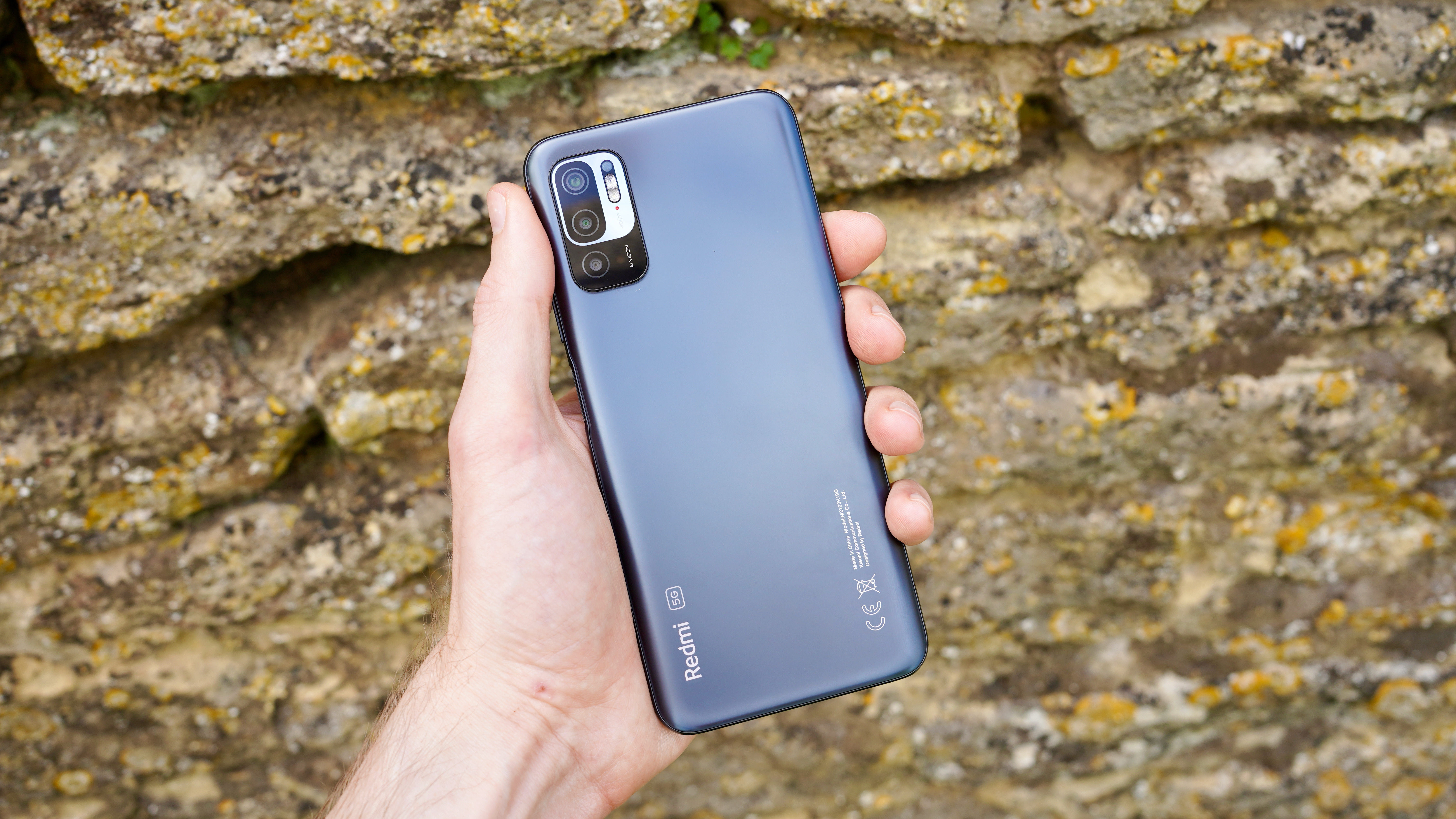 A Xiaomi Redmi Note 10 5G in someone's hand, from the back