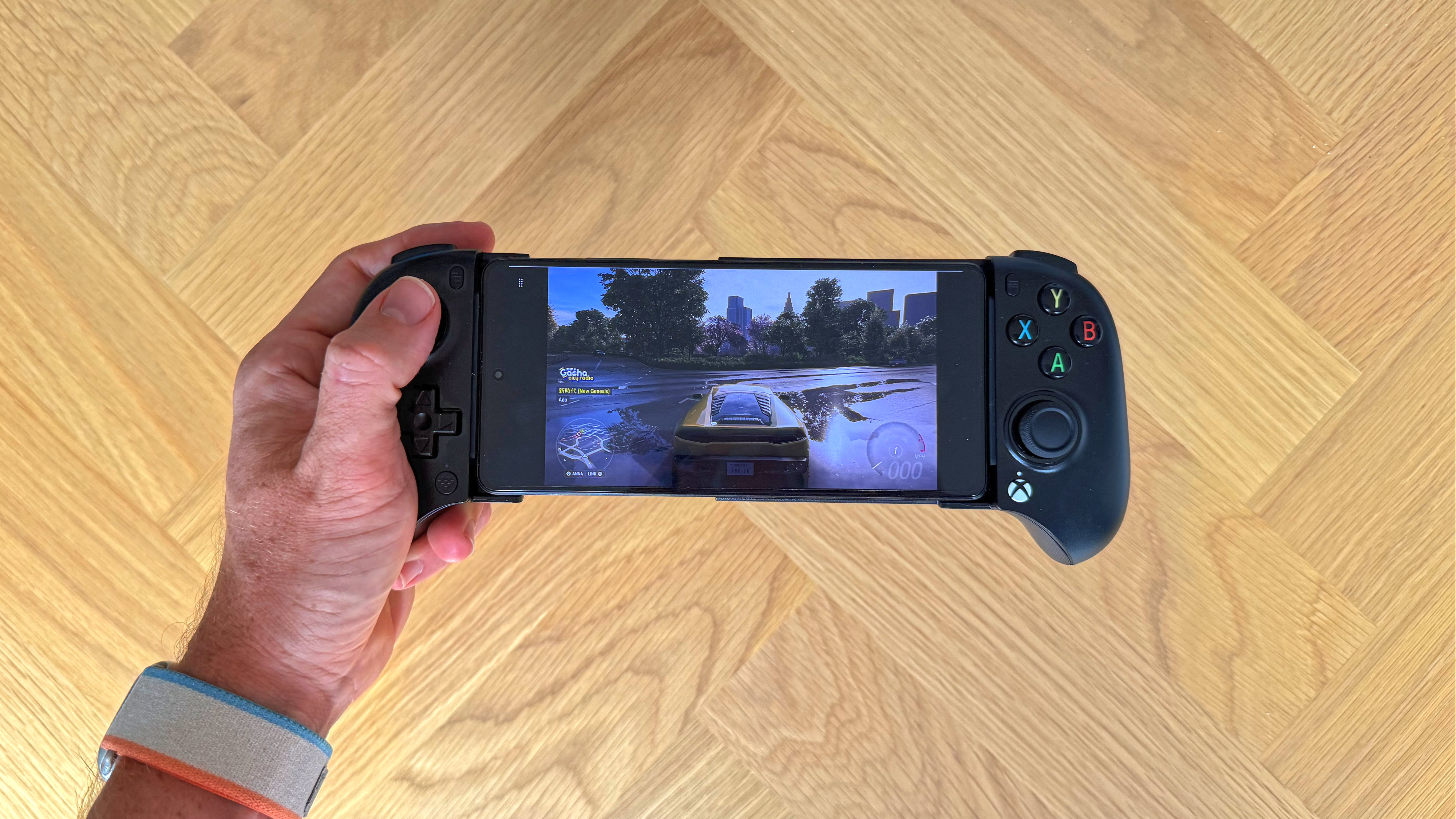 The 8BitDo Ultimate Mobile Gaming Controller - Xbox Edition with the background of a wooden surface.