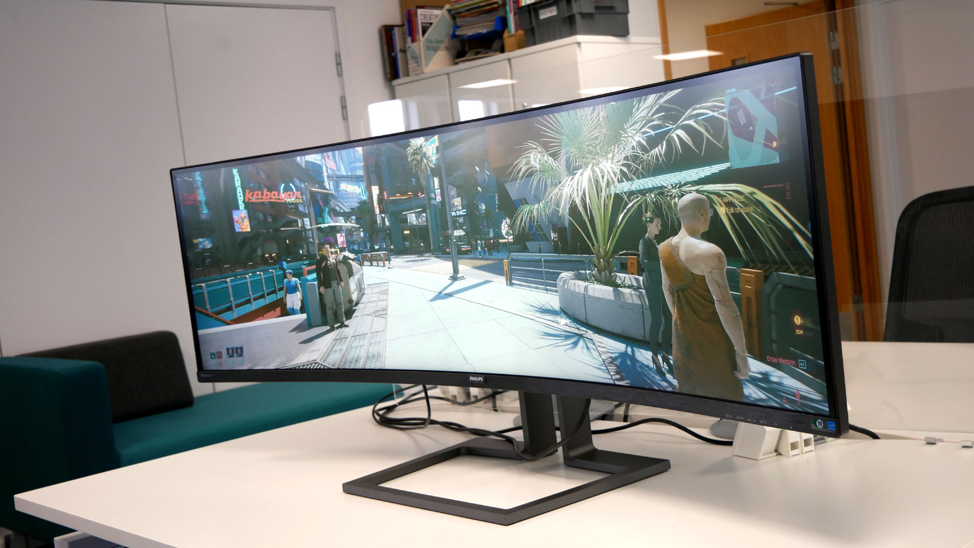 Philips 498P9Z ultrawide monitor on a desk, showing gameplay from Cyperpunk 2077.
