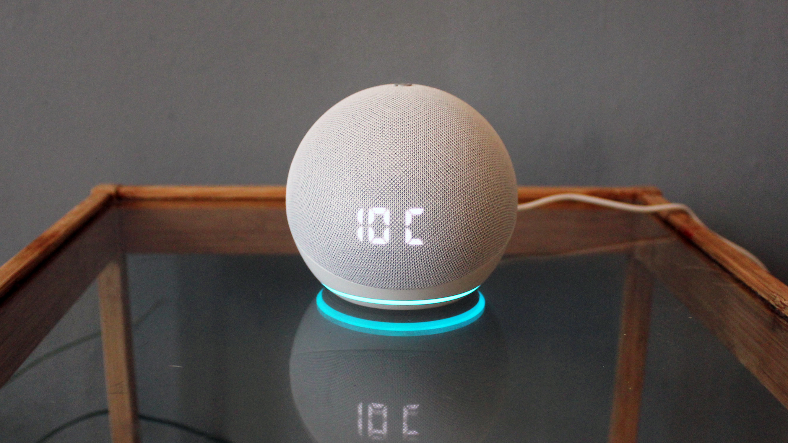 the amazon echo dot with clock on a glass table