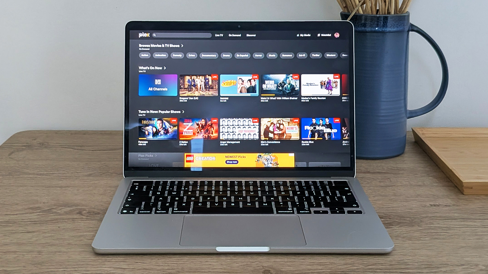 A laptop on a table showing a Plex video library