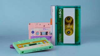 The Gadhouse Miko Cassette Player on a blue blackground, with some cassettes spilling out.