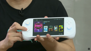 a man holding a white handheld system