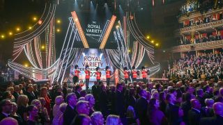 Katherine Jenkins on stage inside the Royal Albert Hall, flanked by trumpet players, as everyone stands to attention for the national anthem before the the Royal Variety Performance 2025 begins.