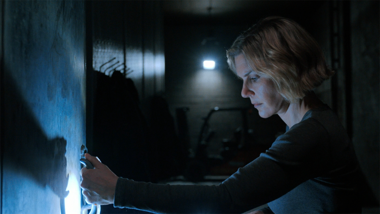 Carol looking down at a refrigerator handle in a dark room in Pluribus episode 5