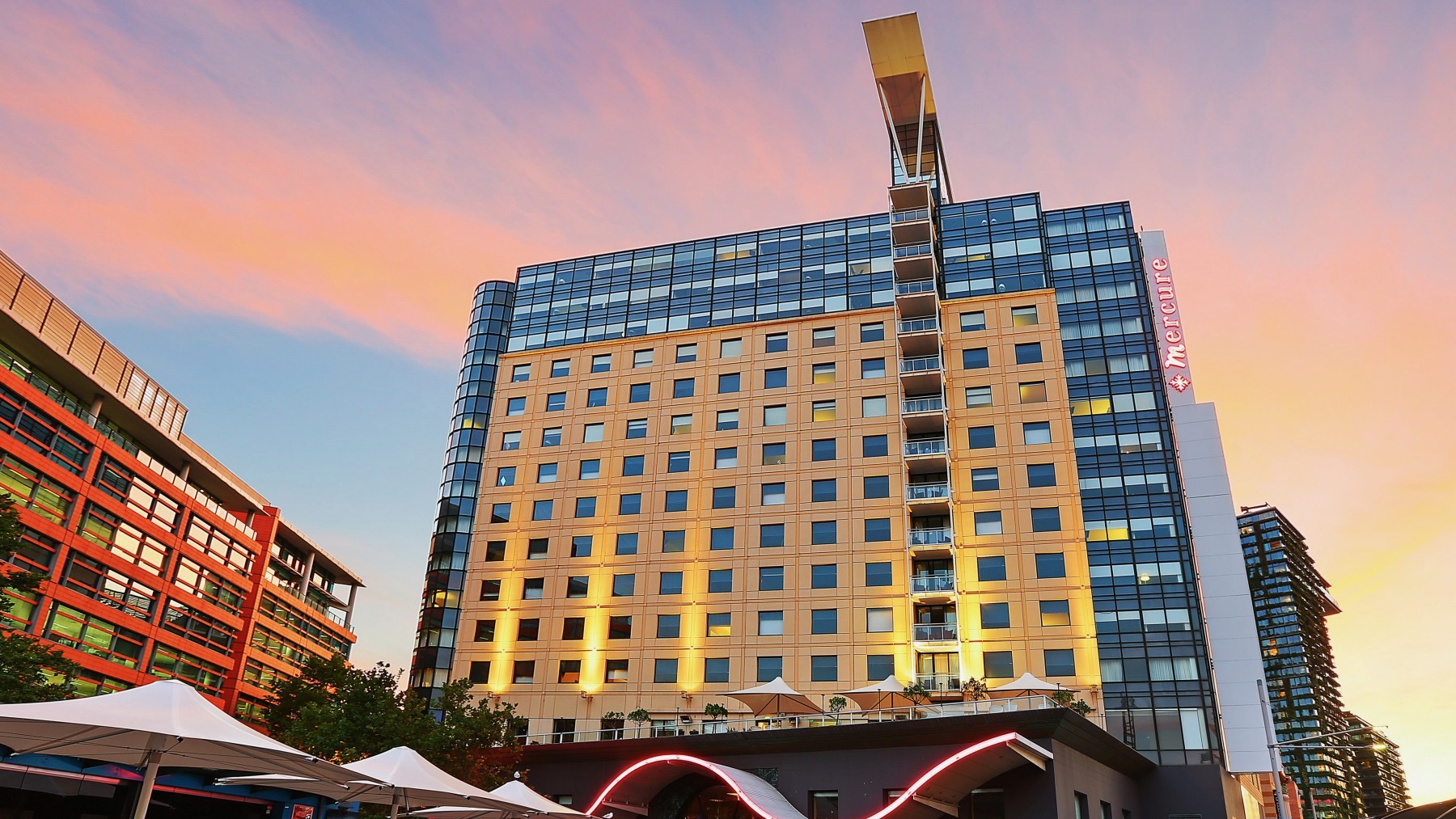 An exterior view of the Mercure Sydney hotel at sunset