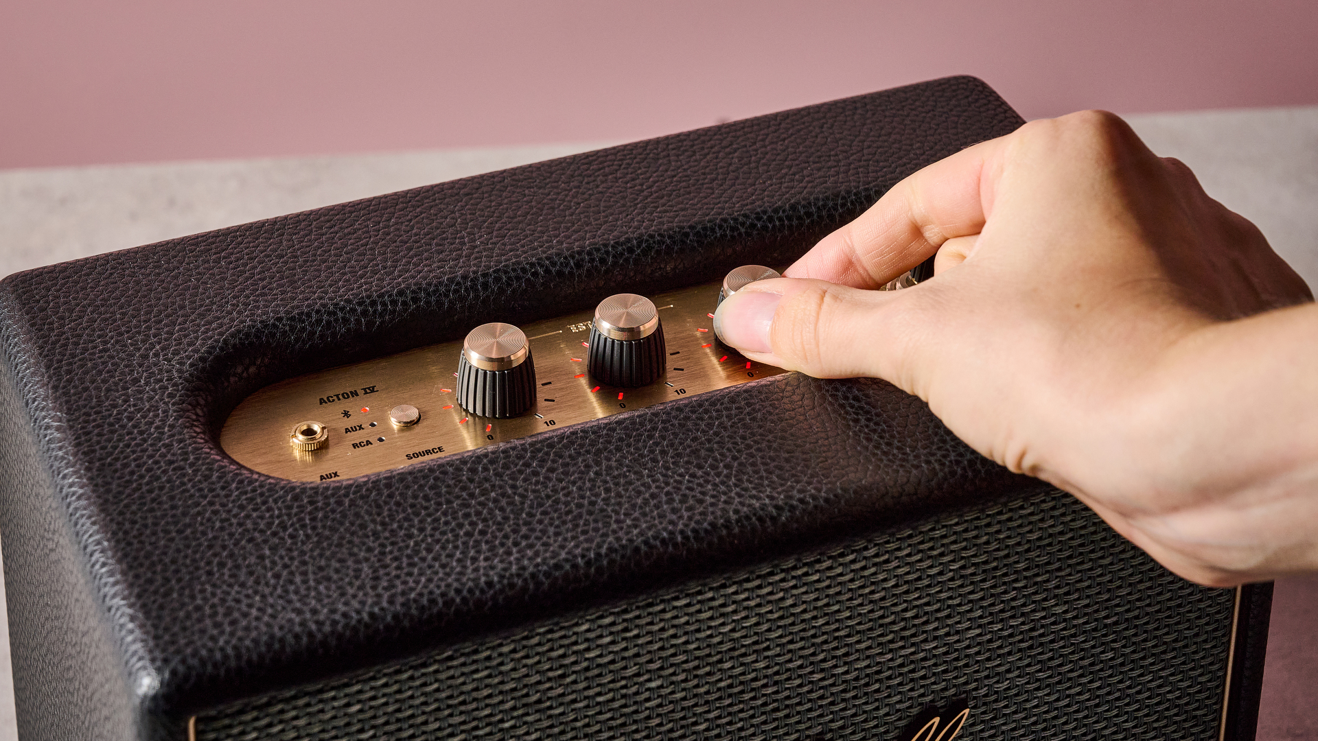 Person turning dial on the Marshall Acton IV
