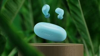 Majority Tru Bio earbuds in blue against a plant background