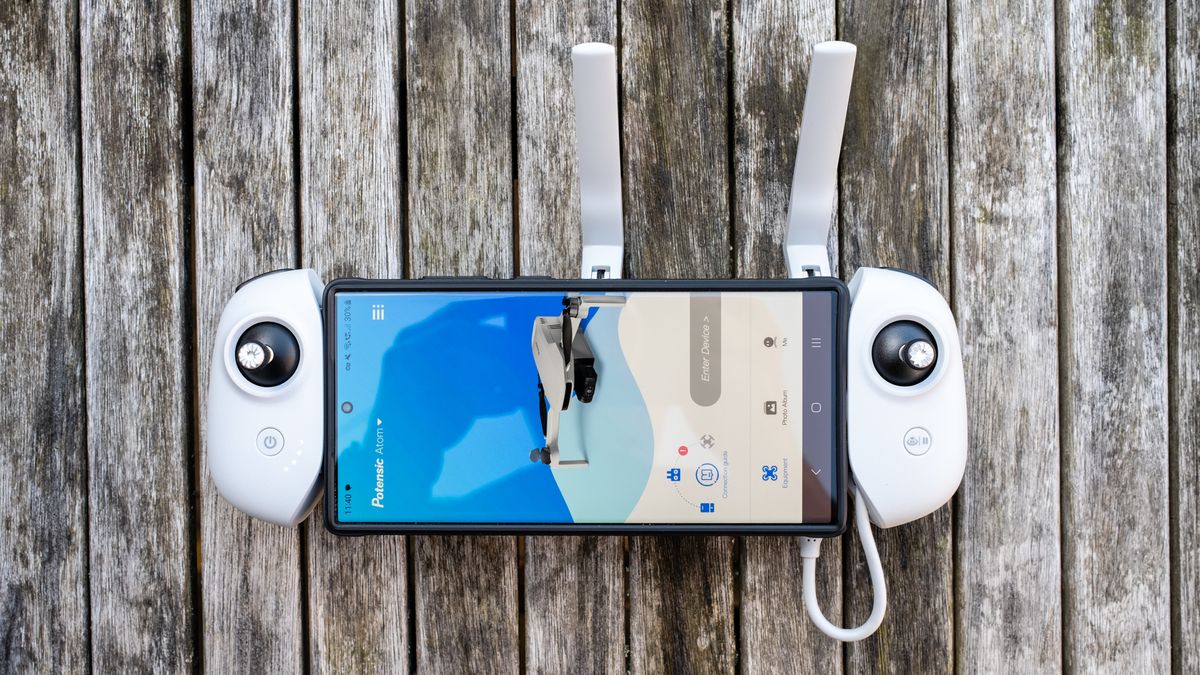 Potensic Atom controller with a phone running the Potensic Pro app
