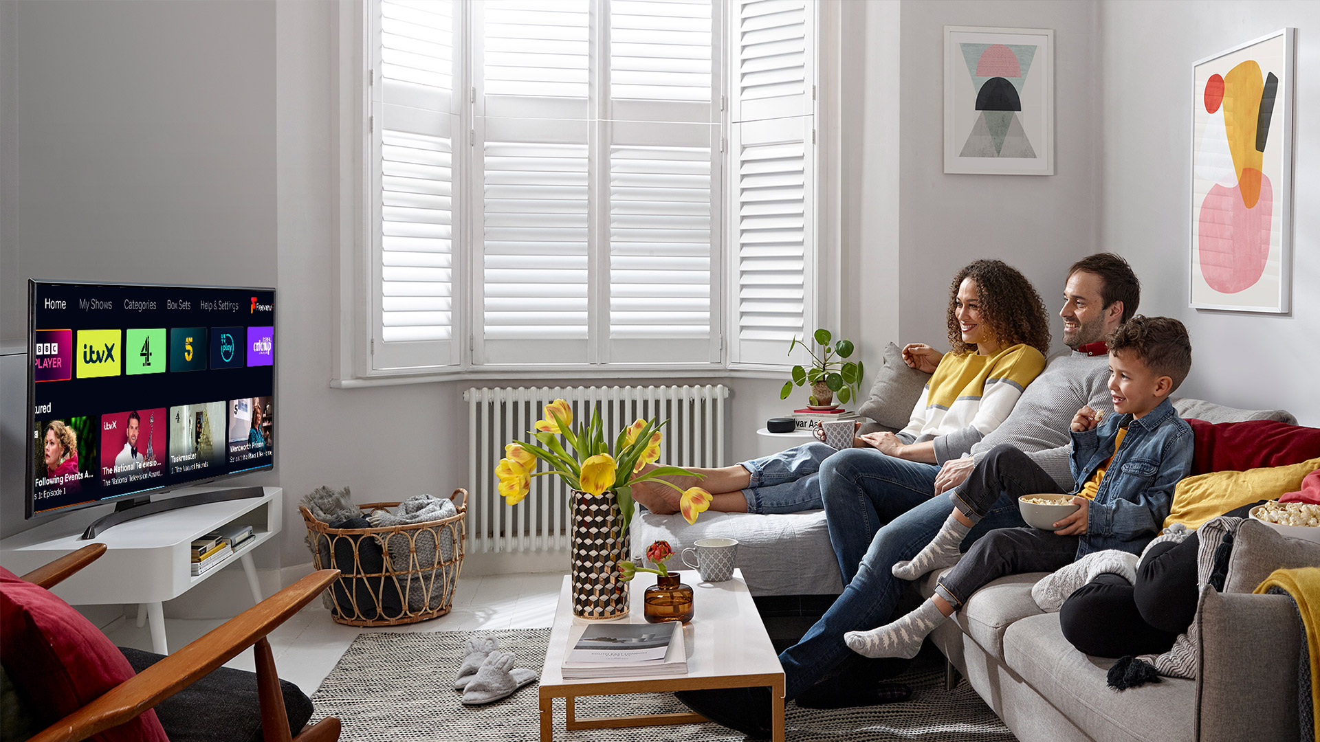 People sit on a couch watching a TV