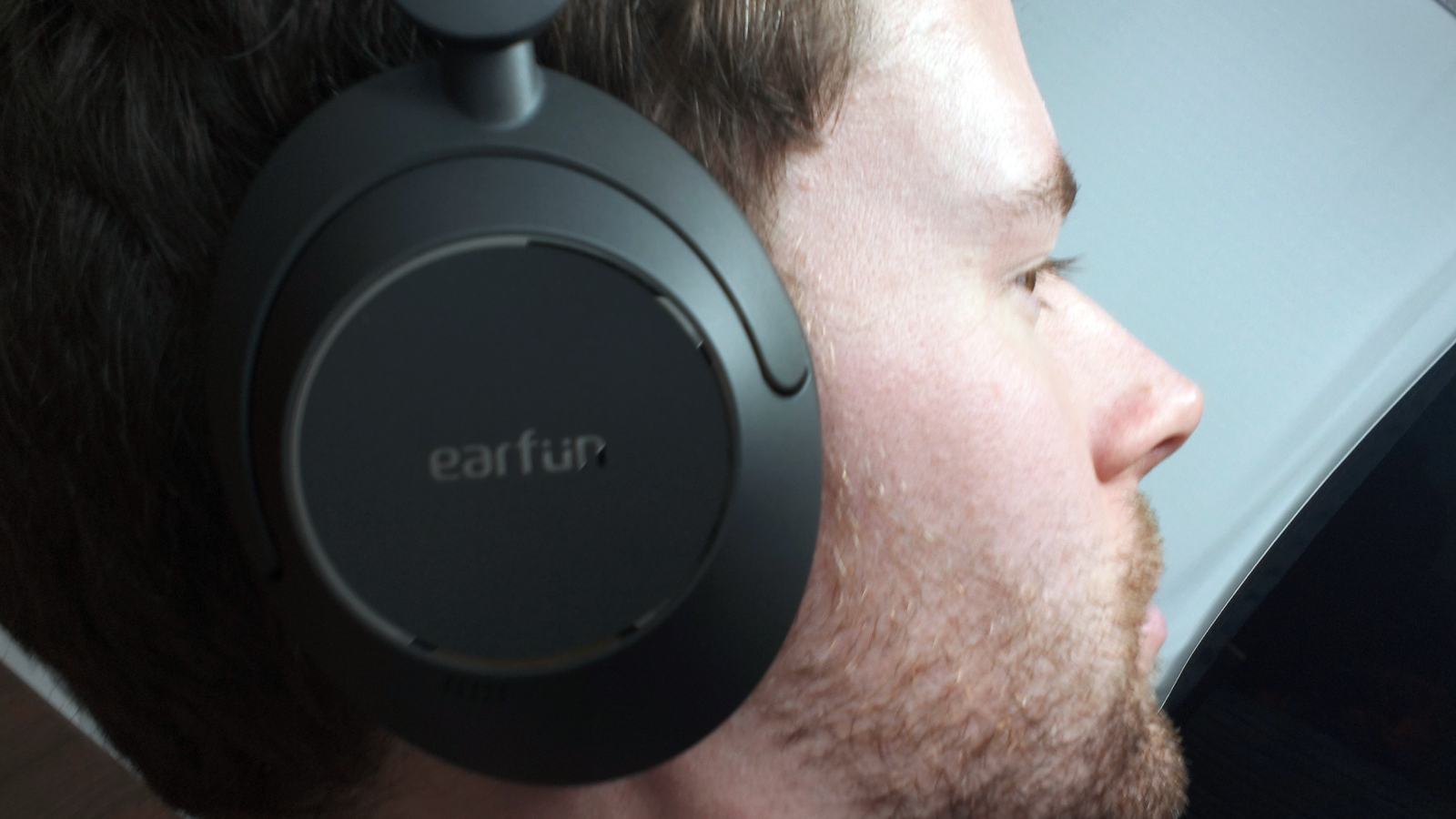 The Earfun Wave Pro on a wooden backdrop.