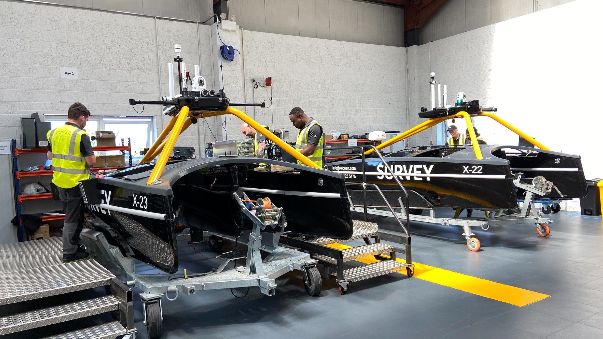 A pair of Uncrewed Surface Vessels undergoing maintenance by engineers at XOCEAN's Rathcor Tech Centre